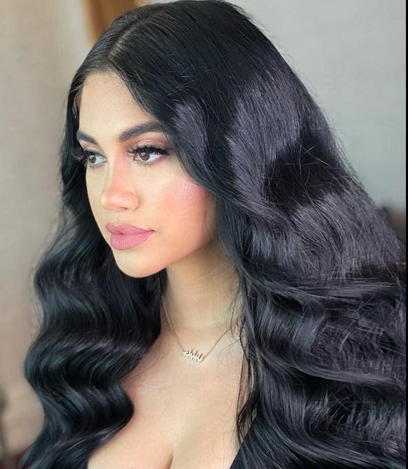 Close-up of Jailyne with voluminous, shiny black hair styled in soft waves, showcasing healthy and glamorous hair results.